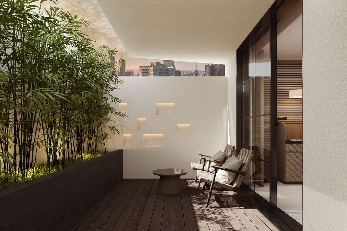 Un balcón moderno con suelo de madera, un rincón de estar con dos sillones, una pequeña mesa redonda y una planta de bambú.