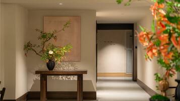 A hallway with a wooden table and a vase of flowers.
