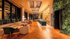 A modern interior with a wooden floor, leather seating, and a green vertical garden. - Superior Twin Room City View HeiwaOdori Room Onl / Hiroshima Hiroshima (Hiroshima)