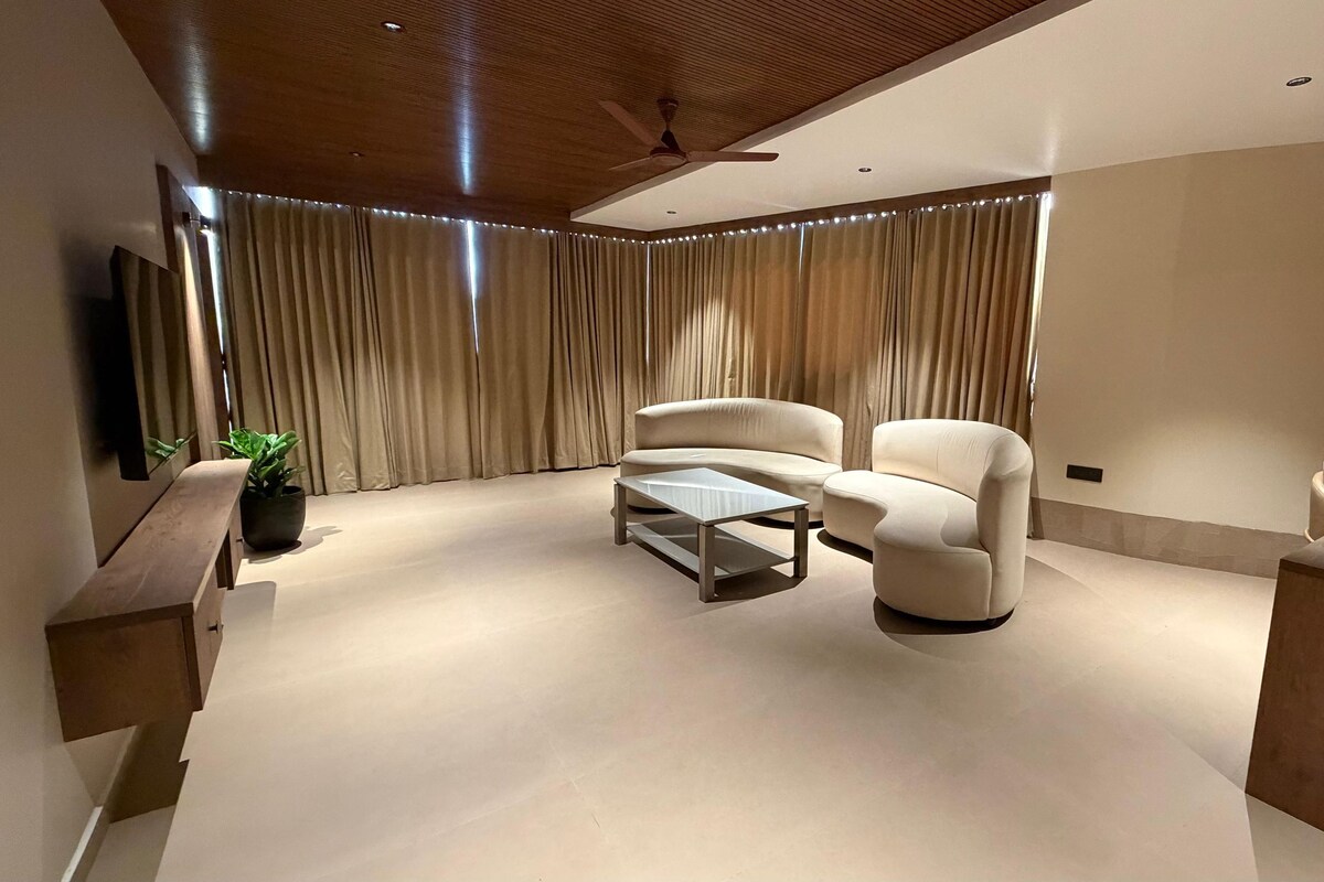 Ein modernes Wohnzimmer mit einer Couch, einem Sessel und einem Couchtisch.