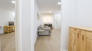 Eine moderne, gut beleuchtete Wohnung mit Wohnbereich, Essplatz und Küchenzeile.
