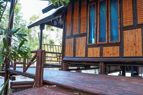 A wooden building with large windows and a wooden deck.