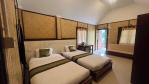 A hotel room with two beds, a small table, and a sofa. - Pai Hillside Resort (Pai)