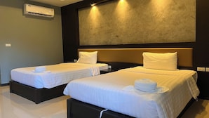 A hotel room with two single beds, a large wall-mounted air conditioner, and recessed lighting. - Namkhem Inn (Takua Pa)