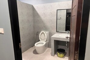 A small bathroom with a toilet, sink, and mirror. - Namkhem Inn (Takua Pa)