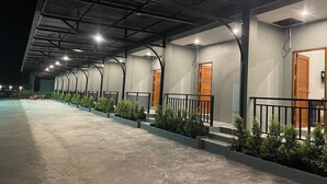A covered outdoor area with multiple doors, each with a small balcony and a black railing. - Namkhem Inn 2 (Takua Pa)