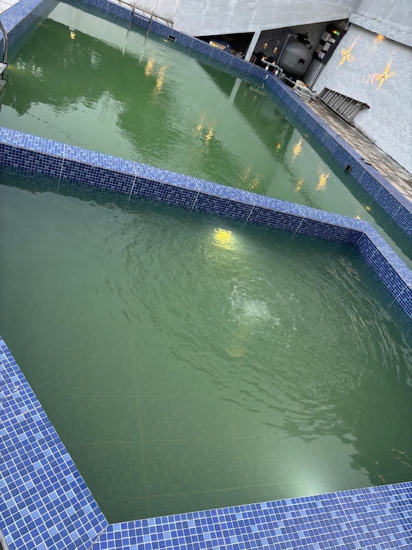 A swimming pool with blue tiles and a clear water surface.