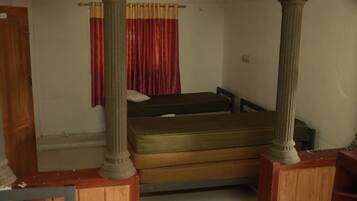 Una habitación con una cama, un banco de madera y una puerta.