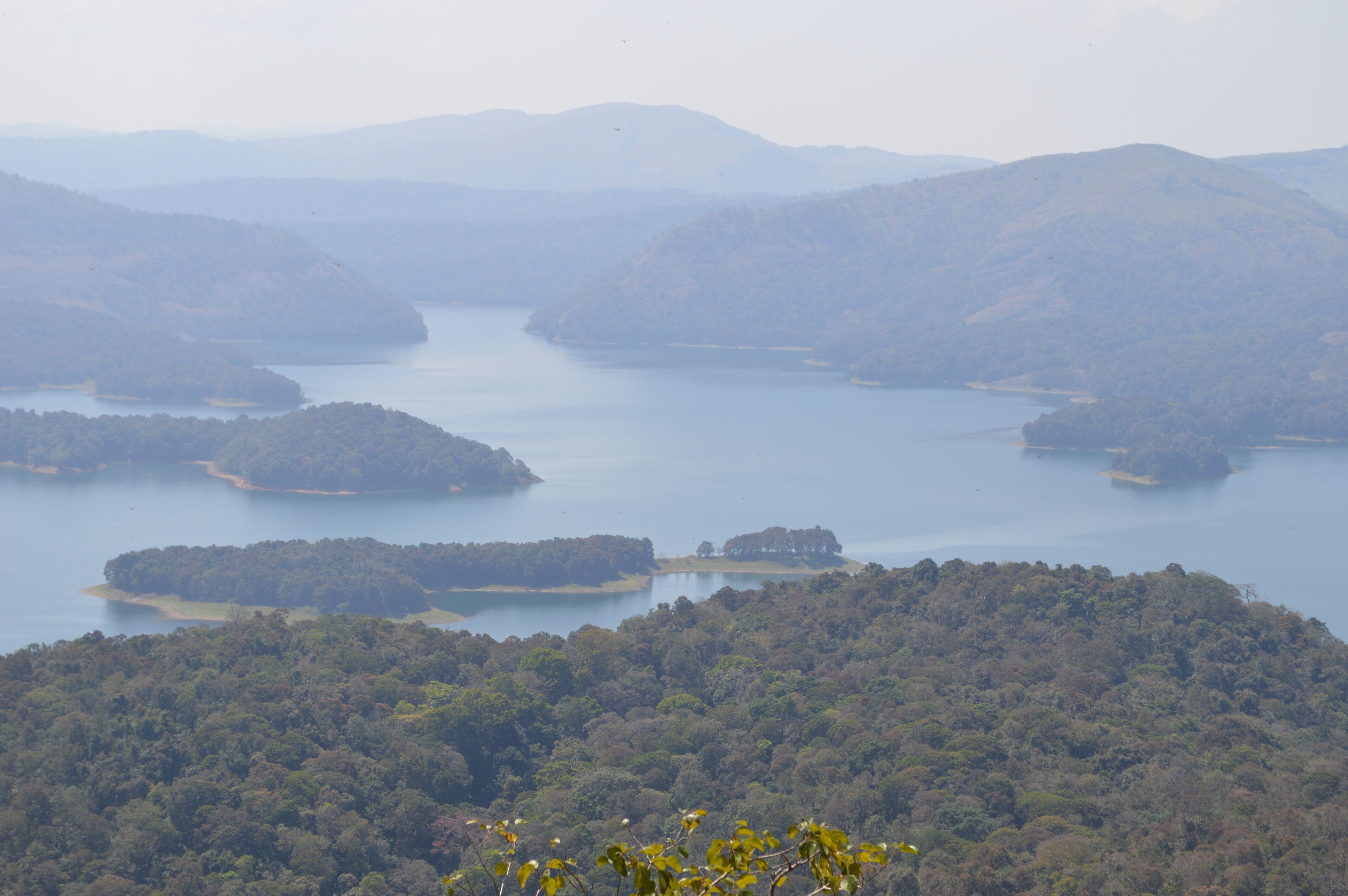 Una vista panorámica de un lago rodeado de colinas boscosas.