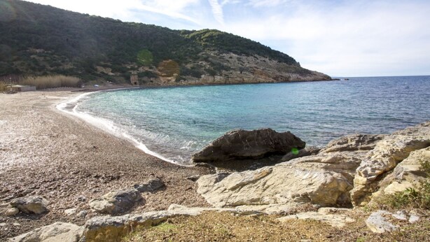 A rocky beach with clear turquoise water and a hilly backdrop. - Cala Rossa 40 Pool & Relax (Rio dell'Elba)