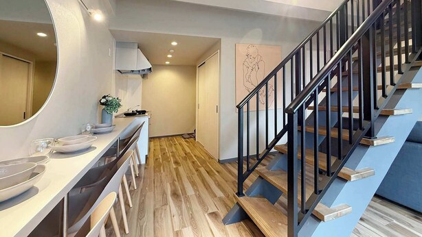 A modern interior with a kitchen, a staircase, and a hallway. - 2-Level Group Stay | 10-min to Hiroshima Station (Hiroshima City)