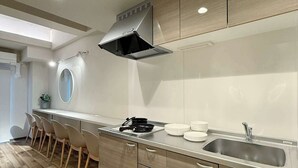 A modern kitchen with a central island, built-in cabinets, and a stainless steel sink. - 2-Level Group Stay | 10-min to Hiroshima Station (Hiroshima City)
