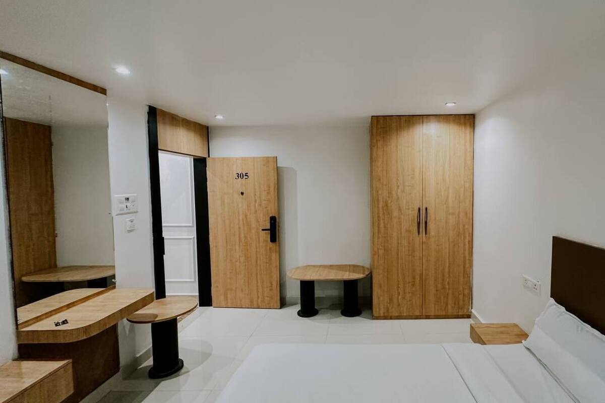 Un dormitorio moderno con cama, armario de madera y una mesita.