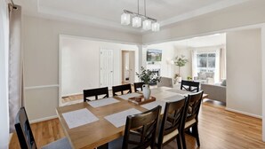 A spacious dining area with a wooden table, black chairs, and a chandelier. - Hialeah Hole in One Golf House (Pinehurst)