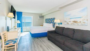 Een hotelkamer met een bed, een slaapbank, een bureau en een stoel.