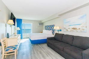 Una habitación de hotel con cama, sofá, escritorio y silla.