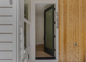 Un couloir avec une porte en bois portant l’inscription « 5284B » et une porte blanche avec une fenêtre.
