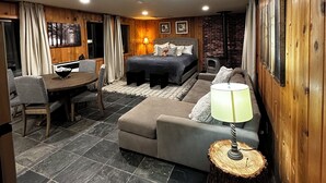 A cozy living room with a bed, a dining table, and a sofa. - Studio style cabin in Twin Bridges with Mountain View’s near Sierra Ski Resorts (Twin Bridges)