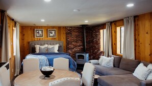 A cozy room with a bed, a sofa, a dining table, and a fireplace. - Studio style cabin in Twin Bridges with Mountain View’s near Sierra Ski Resorts (Twin Bridges)