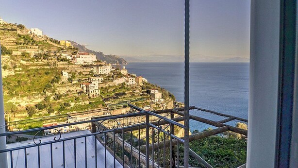 Un balcón con vista a un pueblo costero y al mar.