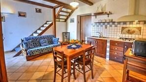 Una cocina acogedora con armarios de madera, una mesa de comedor y una estufa empotrada.