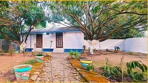 A house with a pathway leading to the entrance, surrounded by trees and potted plants. - The Corbett Canopy Home Stay (Kaladhungi)