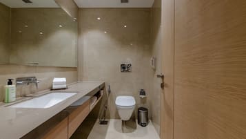 Une salle de bain moderne avec deux lavabos, des toilettes et une poubelle.
