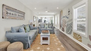 A spacious living room with a sofa set, a coffee table, and a decorative wall piece.