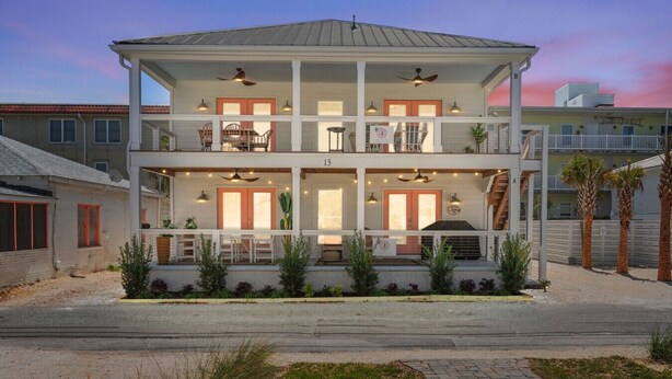 A multi-story building with balconies, outdoor seating, and a barbecue area.