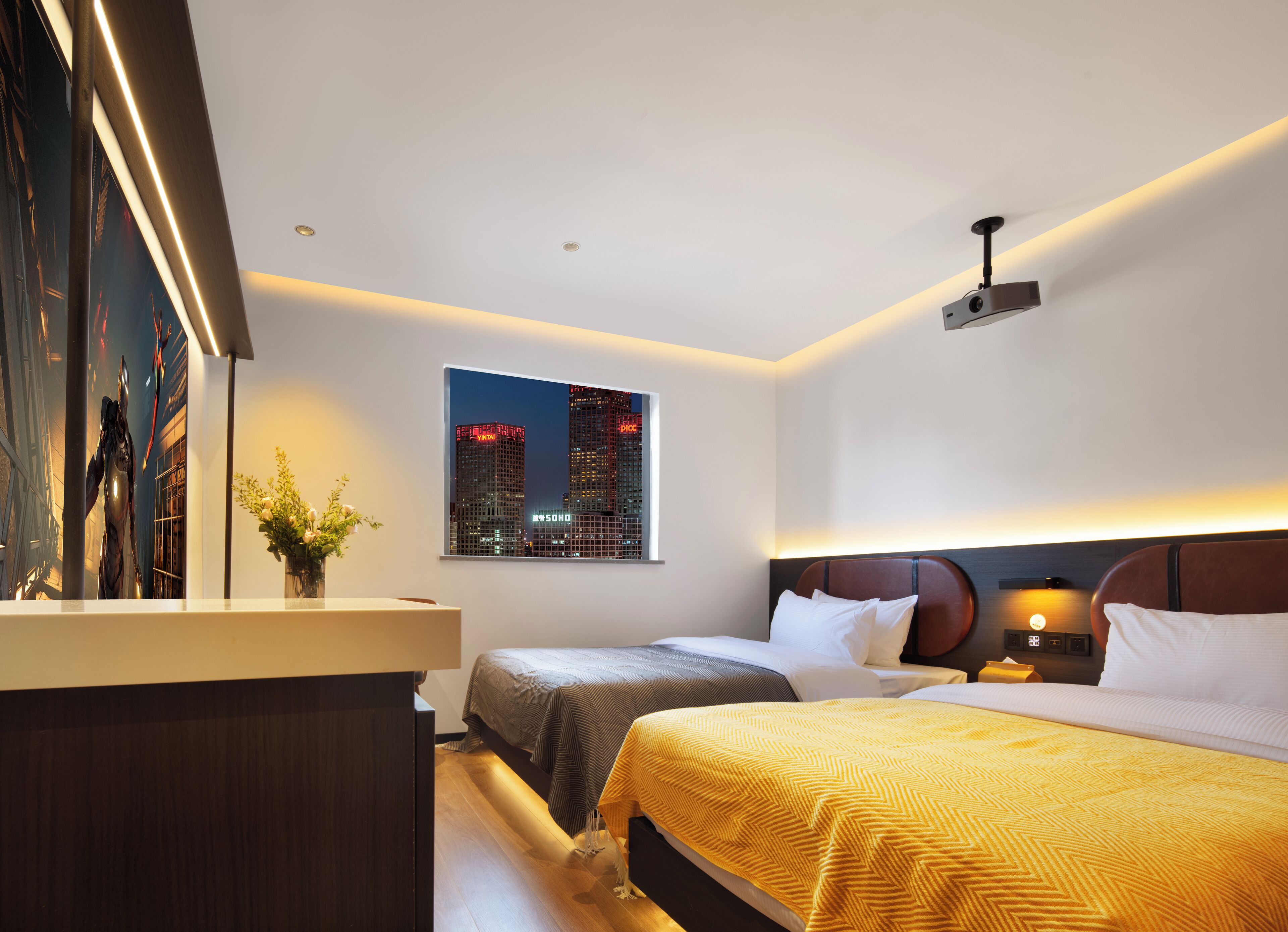 Habitación de hotel con vista a la ciudad, una cama, una mesita de noche y una pequeña zona de escritorio.
