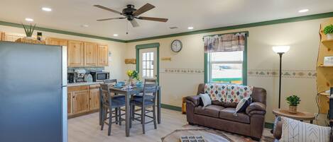 A compact living space with a kitchenette, dining area, and a seating area with a sofa and coffee table.