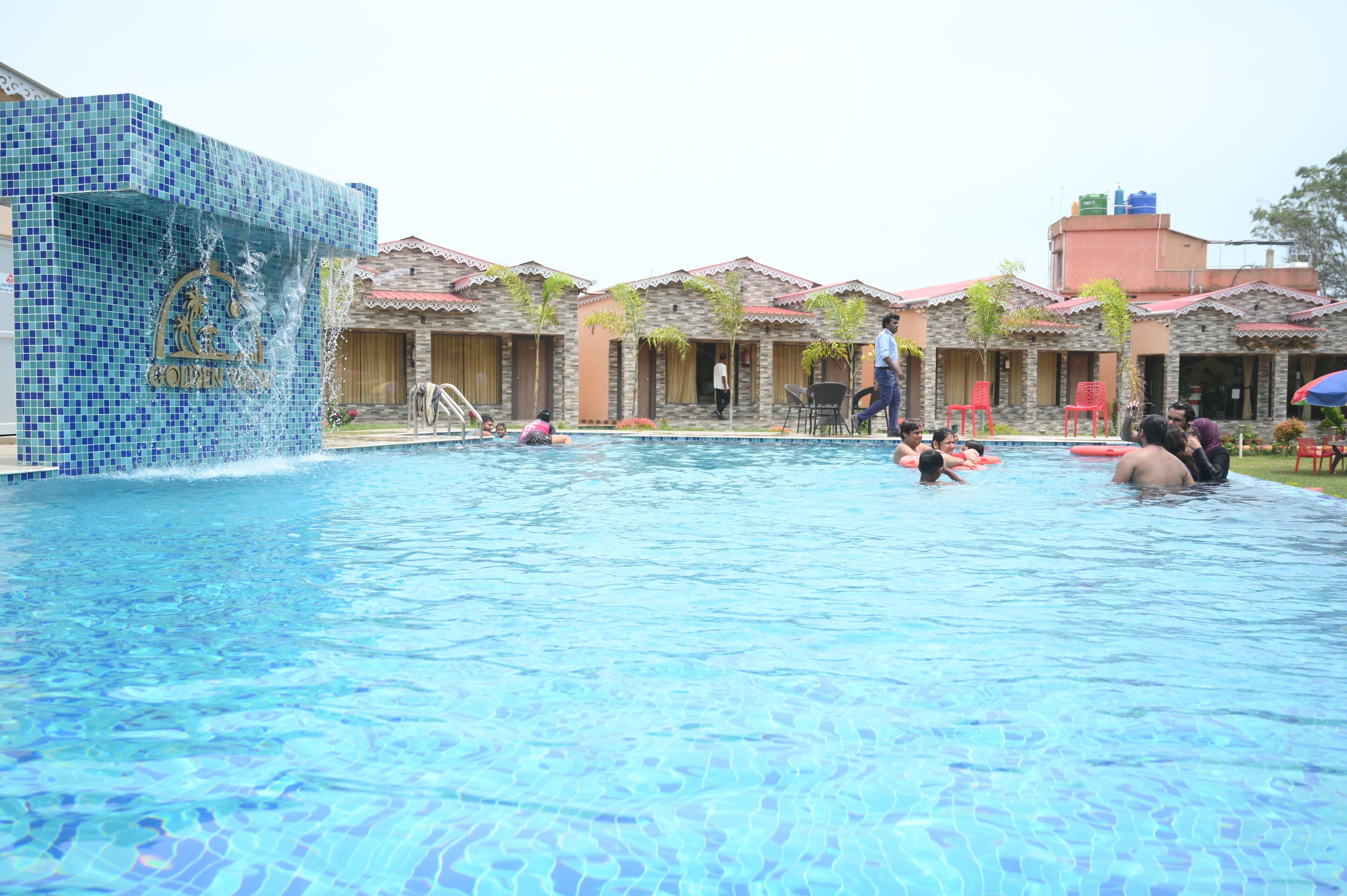 Une piscine aux murs recouverts de carreaux et dont l’eau est d’un bleu limpide.