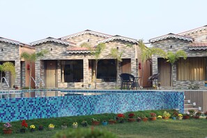 A row of spa-style buildings with a swimming pool in front. - Golden View Resort & Restaurant (Kanthi)