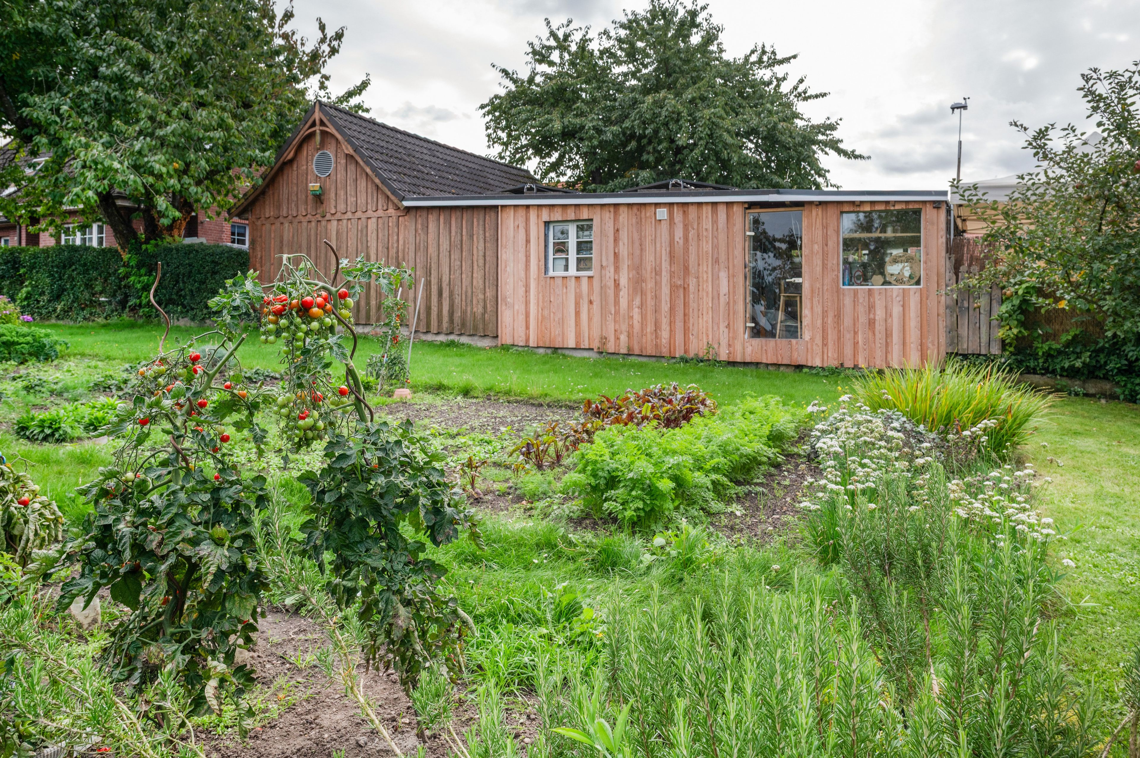 Ein Holzhaus mit einem Garten davor.