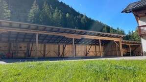 A wooden building with a covered porch and a mountain backdrop.