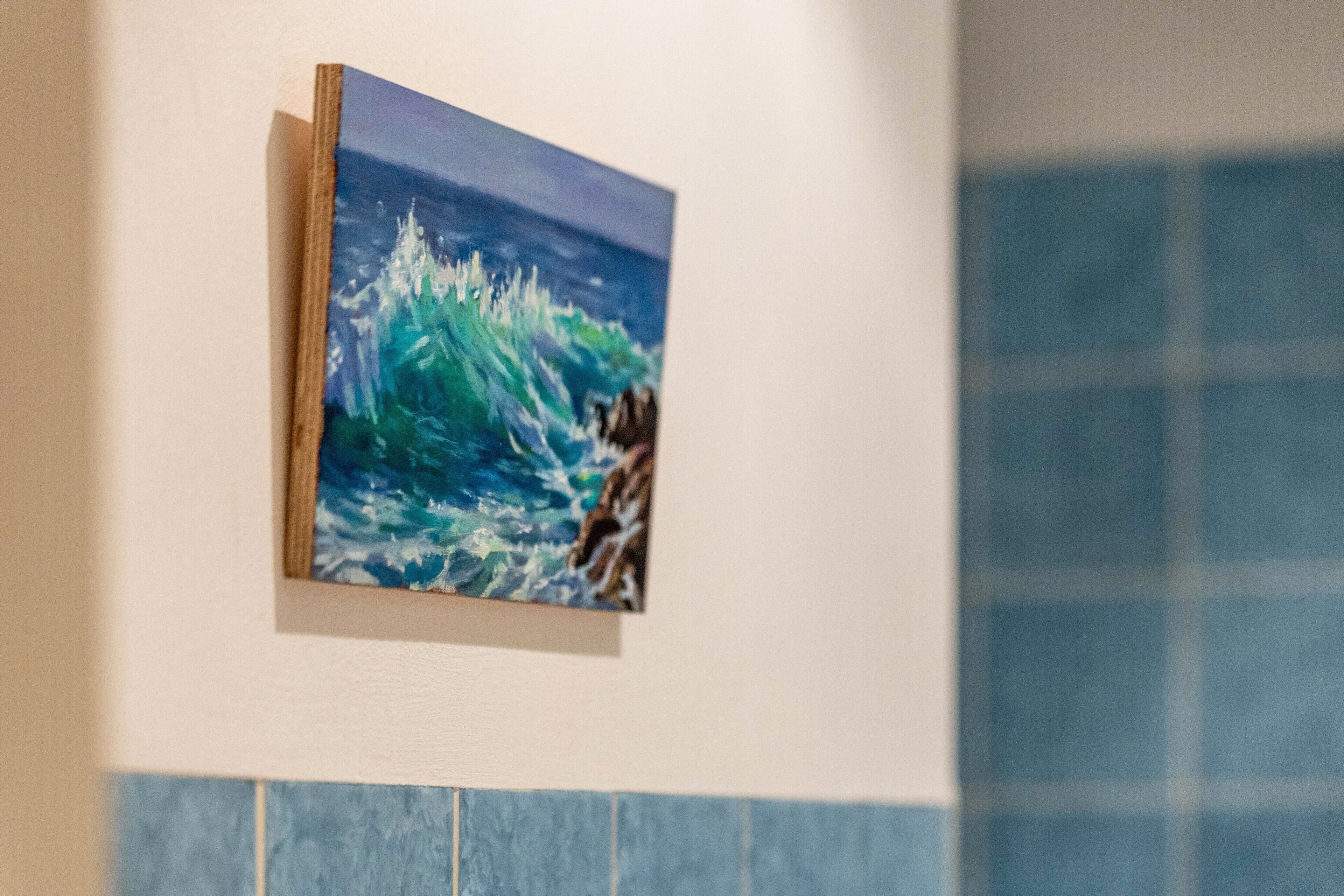 Ein Gemälde einer Welle an einer Wand.