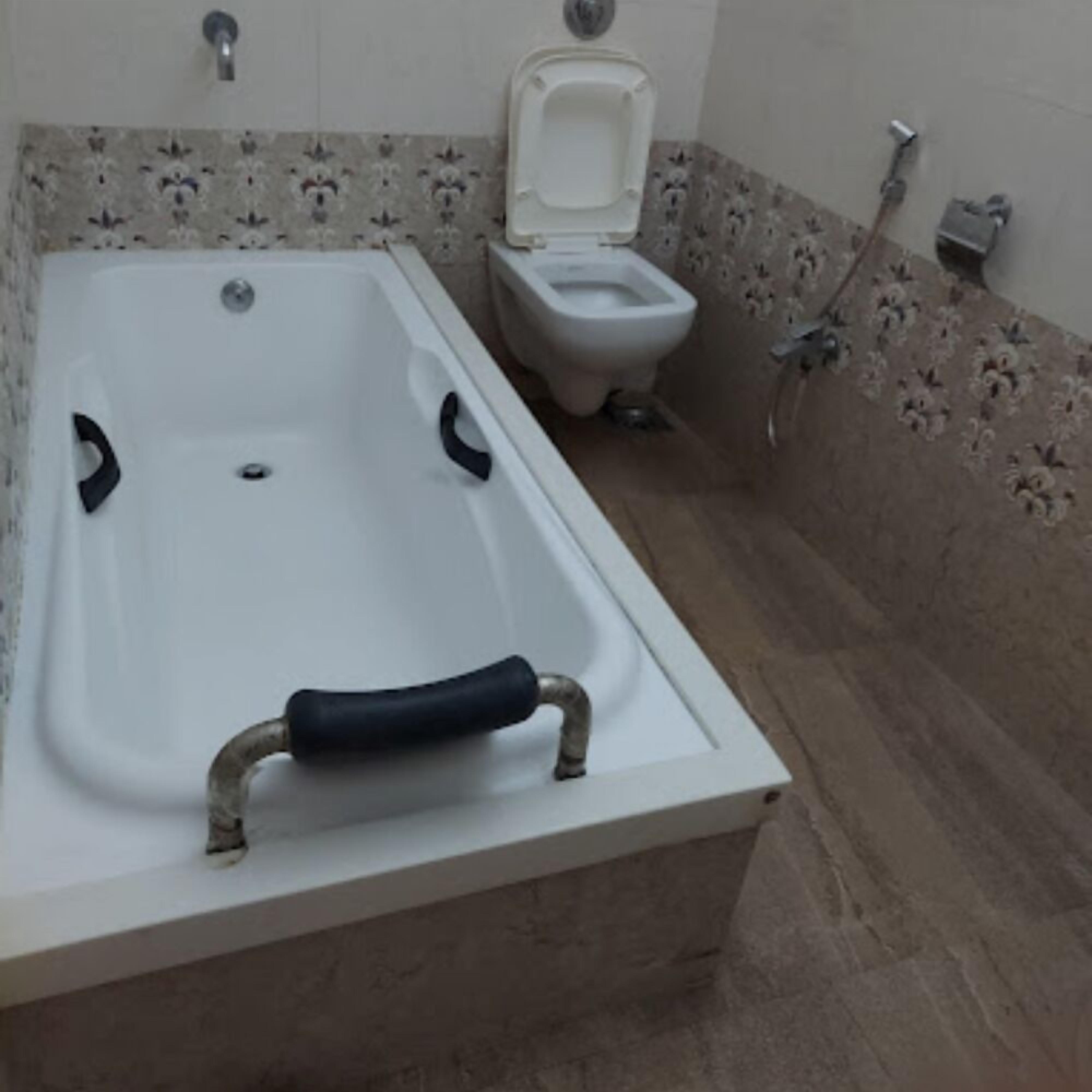 A bathroom with a bathtub, toilet, and a shower area.