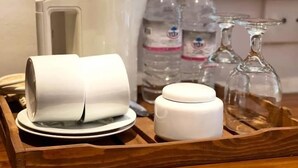 A tray with a coffee maker, two bottles of water, and two glasses.