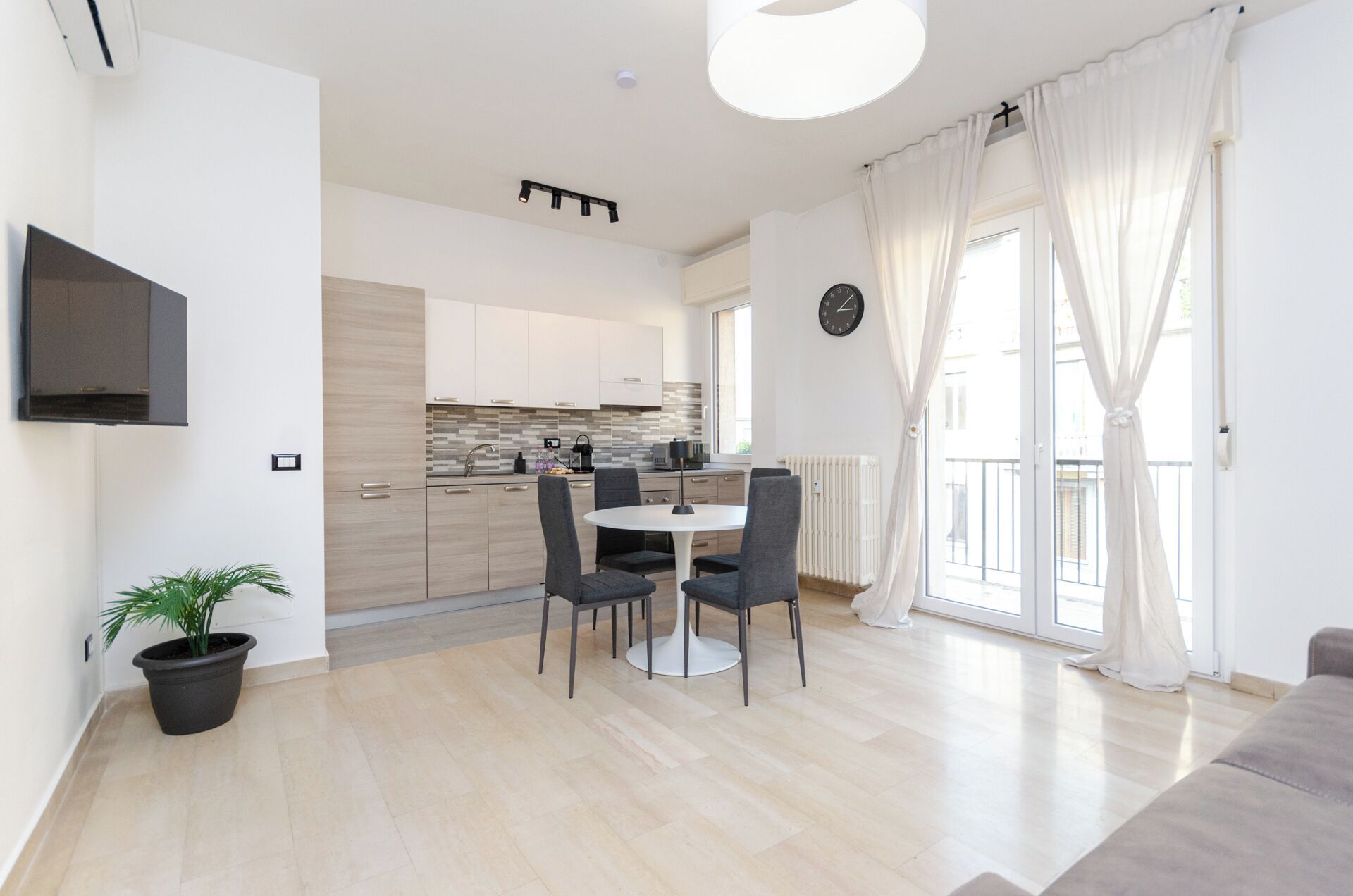 Un appartamento moderno con cucina, zona pranzo e soggiorno.