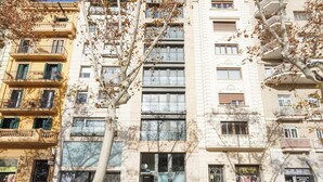 A multi-story building with balconies and windows, featuring a mix of architectural styles.