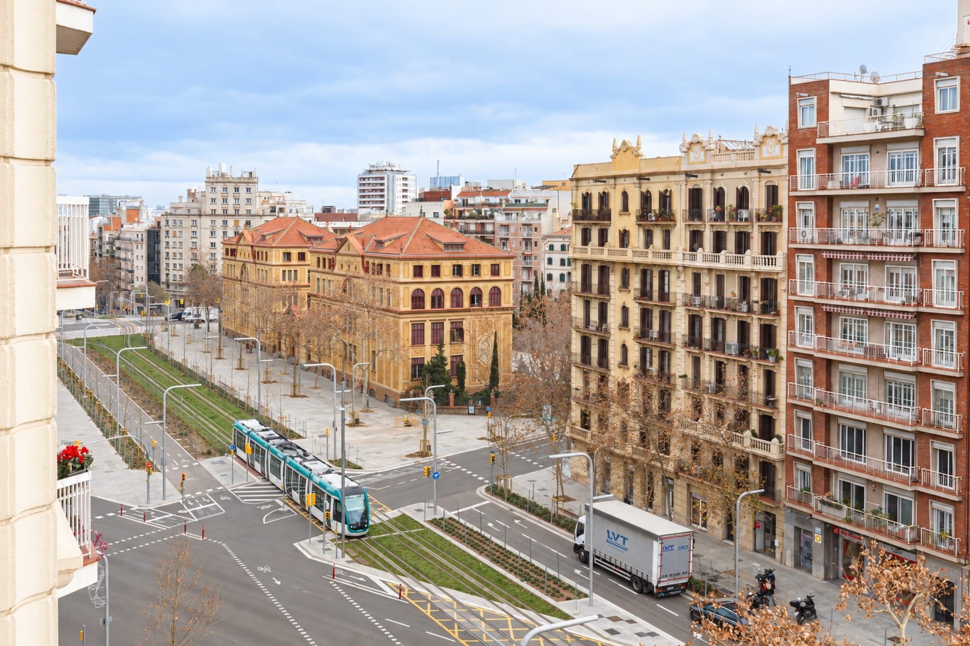 A city street with a tram, buildings, and a clear sky.