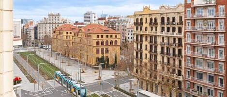 A city street with a tram, buildings, and a clear sky.