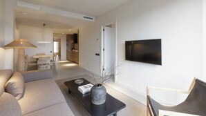 Un salon moderne avec un canapé, une table basse et un téléviseur fixé au mur.