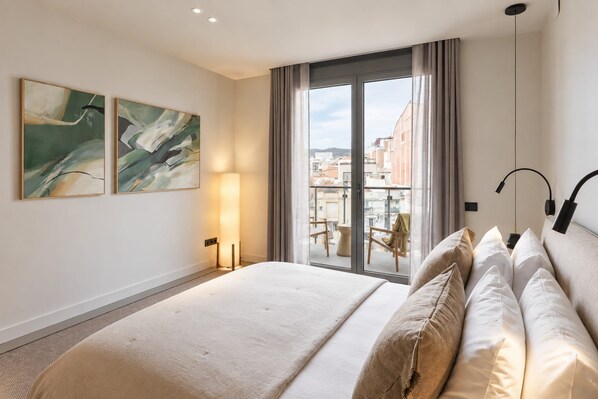 A hotel room with a large bed, a balcony with a view, and two abstract paintings on the wall.