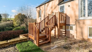 Une maison à deux étages avec un escalier en bois menant à un balcon.