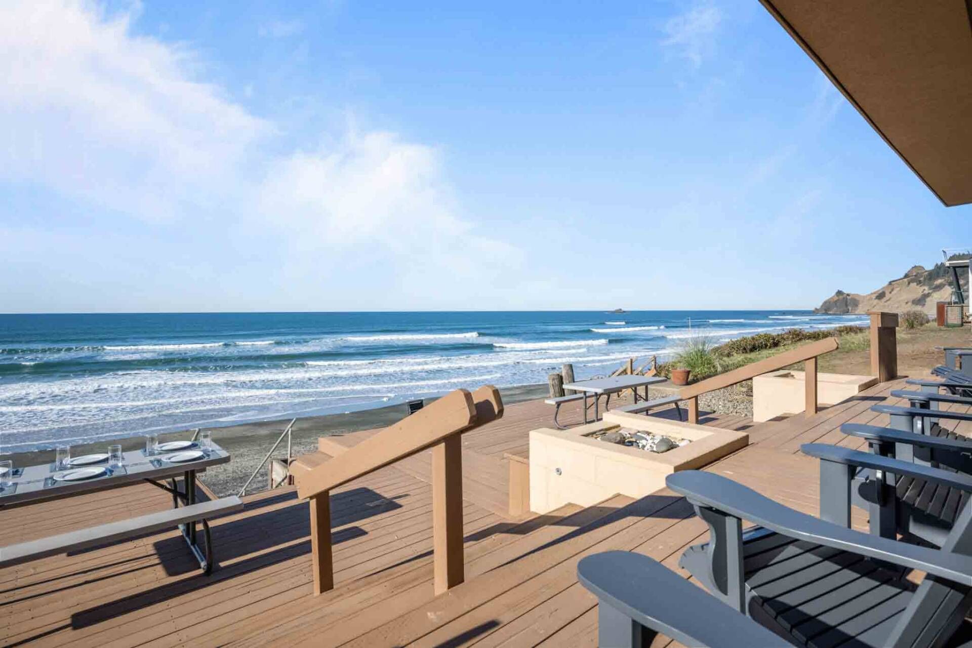 Un terrazzo in legno con posti a sedere all'aperto con vista sull'oceano.
