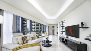 A modern living room with a sofa, coffee table, and TV. - Glamorous 2BR in Damac Paramount Tower (Dubai)