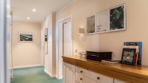A hallway with a wooden counter, framed pictures, and a book titled 'Hunderwasser'. - Room 'Doppelzimmer 3' with Mountain View and Wi-Fi (Seefeld in Tirol)