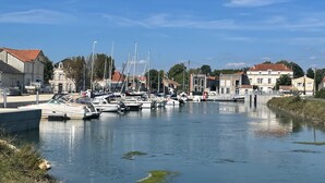 Marina con varias embarcaciones amarradas, rodeada de edificios con tejados rojos.