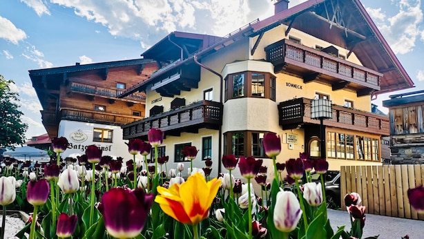 Un hôtel de style architectural alpin traditionnel, doté de balcons et d’une enseigne portant l’inscription « Sonneck ».